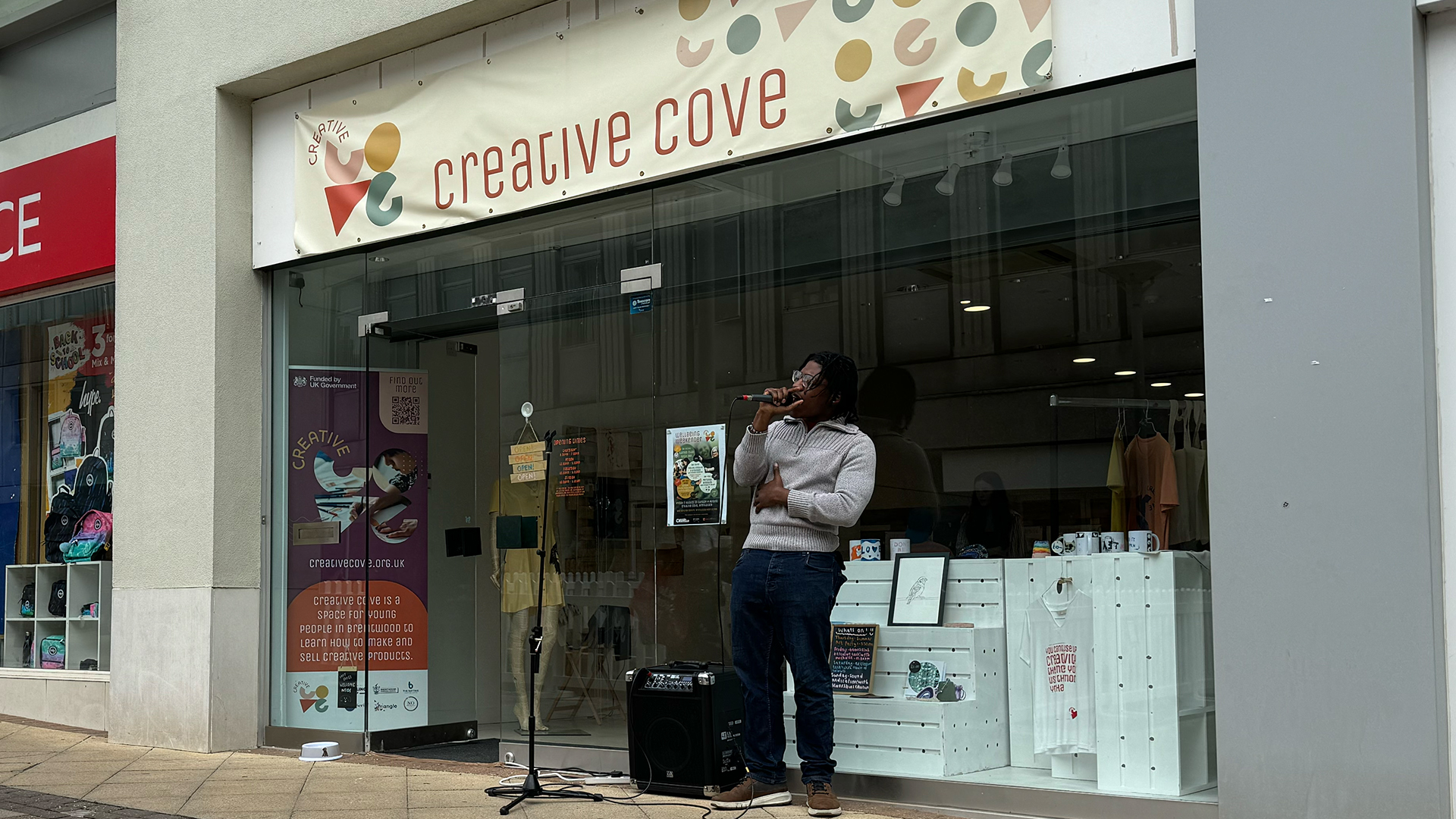 A young person performs a song outside of the Creative Cove